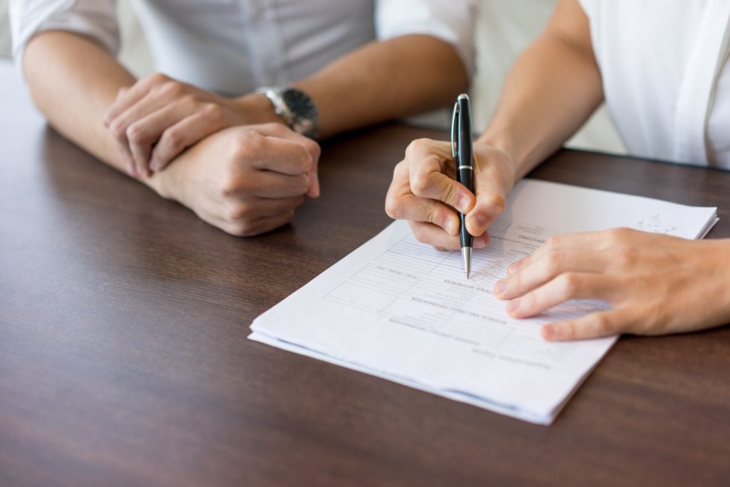 pessoas assinando o Contrato de financiamento de imóvel.