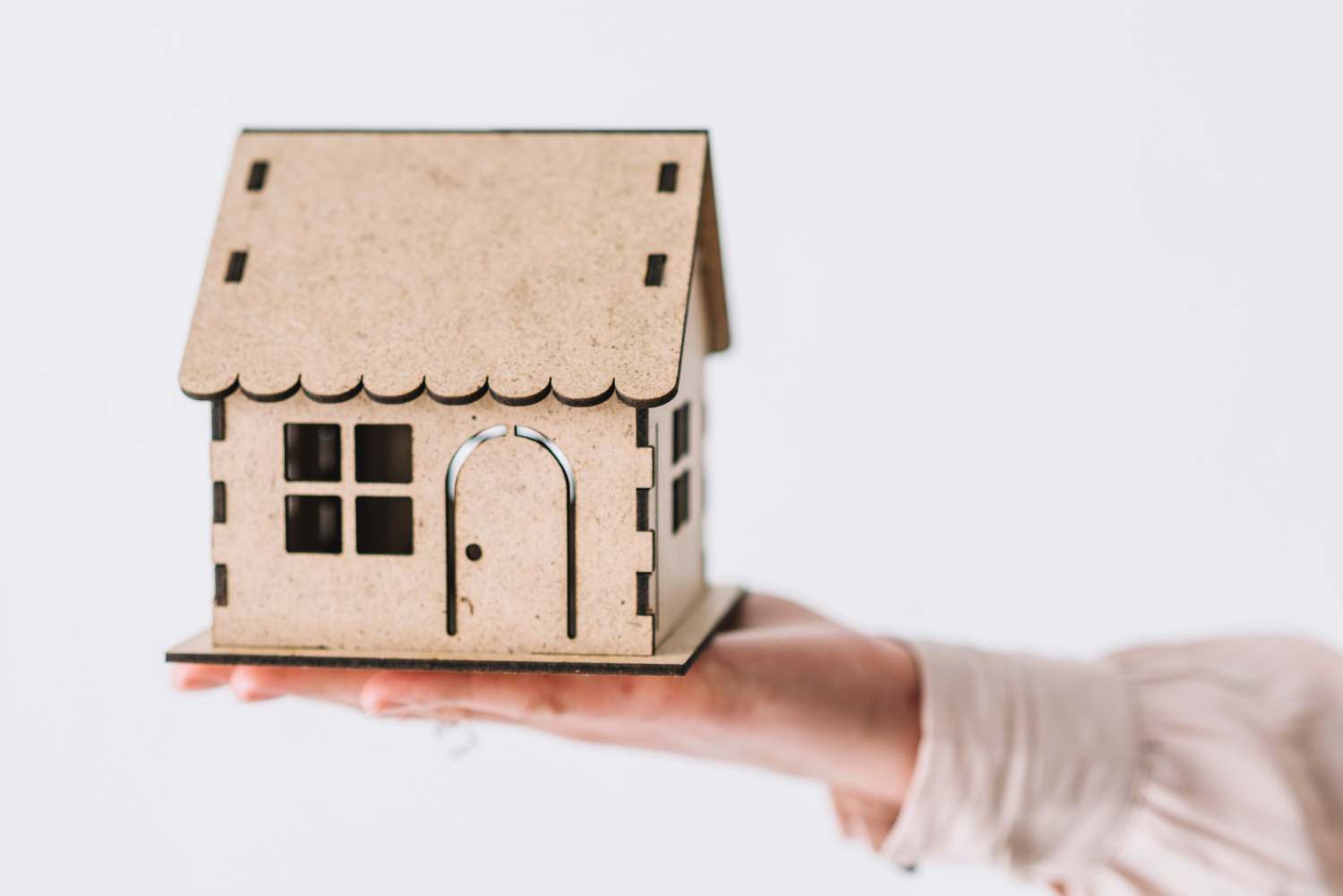 pessoa segurando miniatura de casa para ilustrar habitação de interesse social.