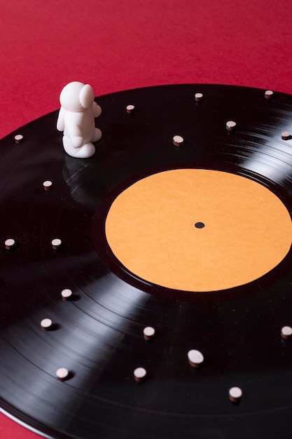 A close-up of a vinyl record player with a K-Drama OST album on the turntable. The needle is gently touching the record, and soft, warm lighting highlights the scene. In the background, there's a blurred image of a K-Drama scene playing on a nearby screen.